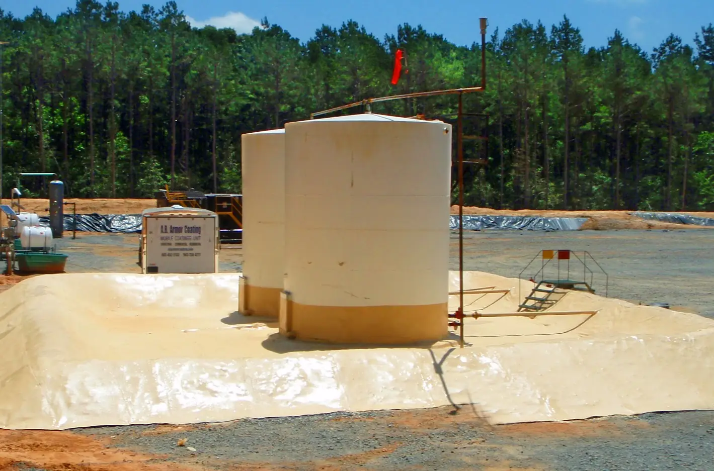 Storage tank standing on a freshly lined earth containment berm